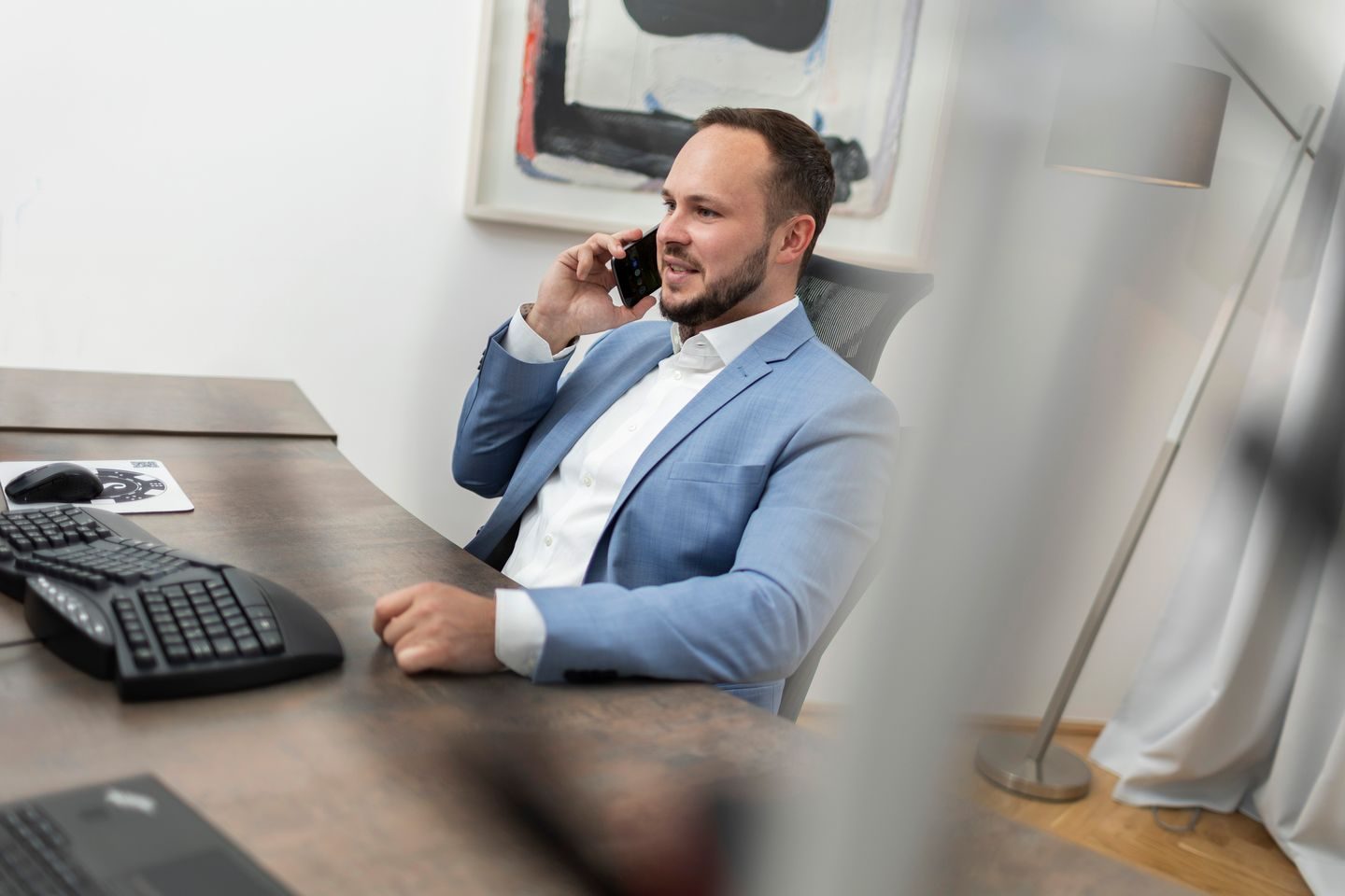 Ronald Mechtler am Schreibtisch im Telefonat, R. M. Prozessfinanzierung GmbH